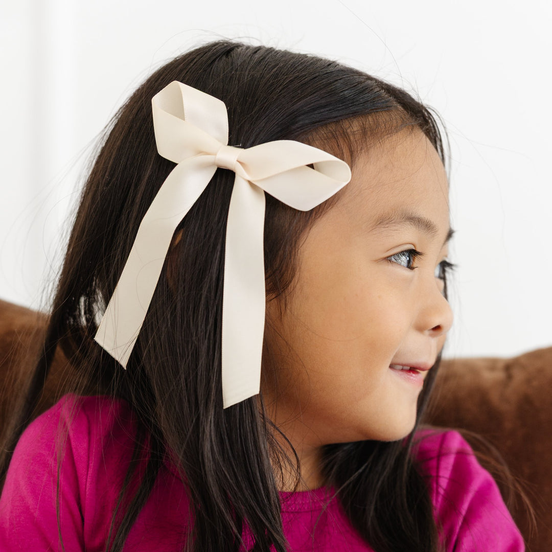 little girl wearing pastel yellow hair bow
