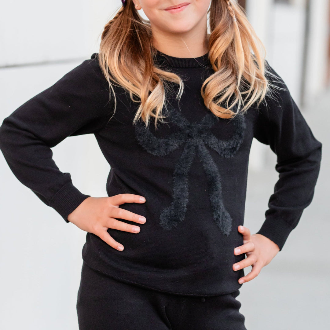 girl in black cotton knit sweater with fluffy black bow design for Halloween