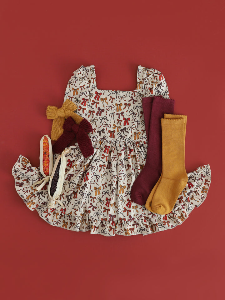 girls' cream short sleeve twirl dress with bow print in fall shades and coordinating knee high socks and hair bows