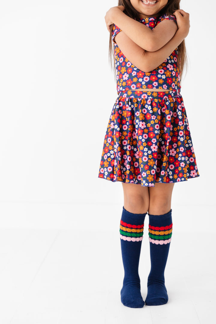 girl in back to school set of tee and skort in navy floral print and matching navy bubble knee highs