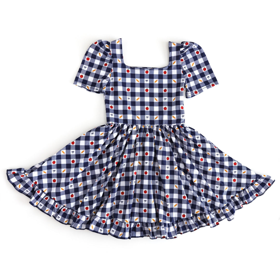 girl's short sleeve, square neck back to school dress in navy and white gingham with apple, pencil and bow print details
