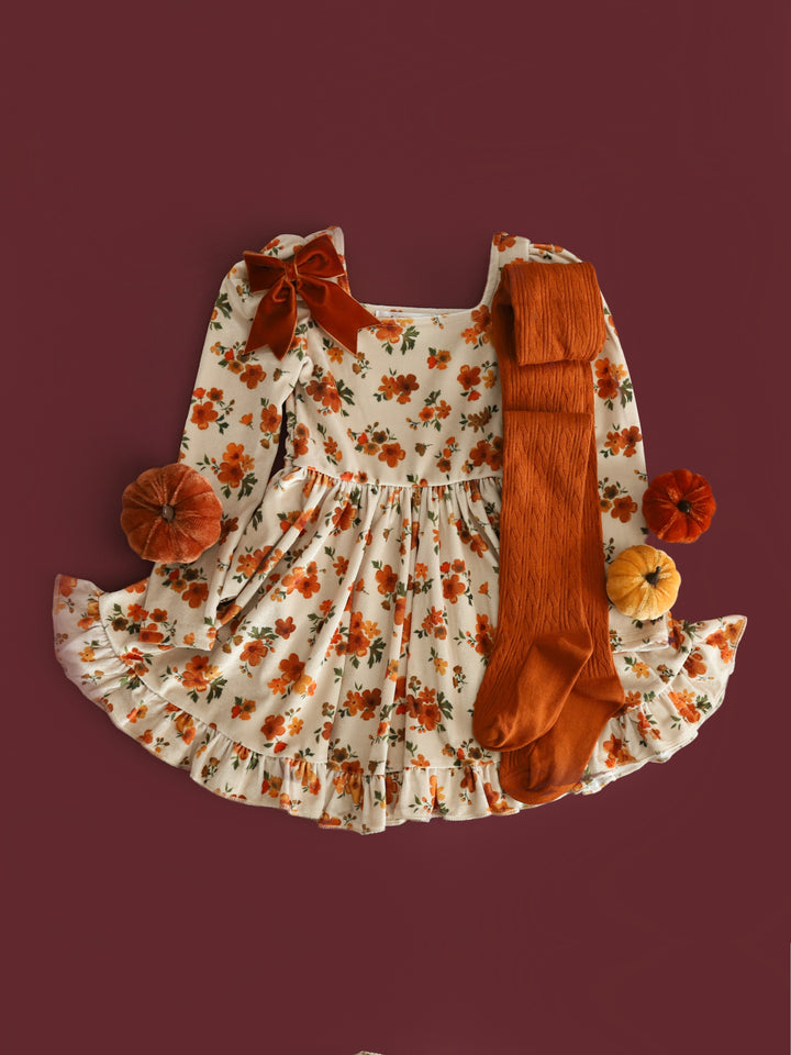 styled flatlay featuring cream velvet long sleeve twirl dress with pumpkin spice floral and pumpkin spice tights and bow for fall and thanksgiving