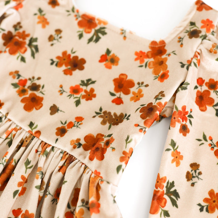 closeup of bodice on girls' cream velvet dress with orange and brown flowers for fall
