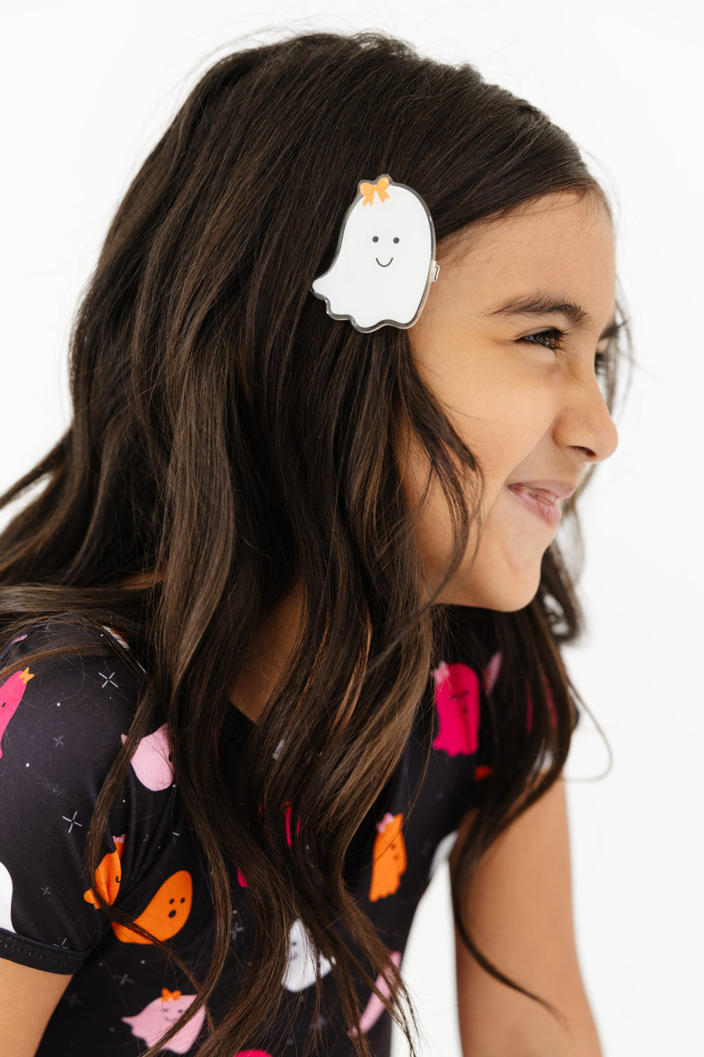 little girl in white acrylic ghost clip with orange bow detail and matching ghost print top