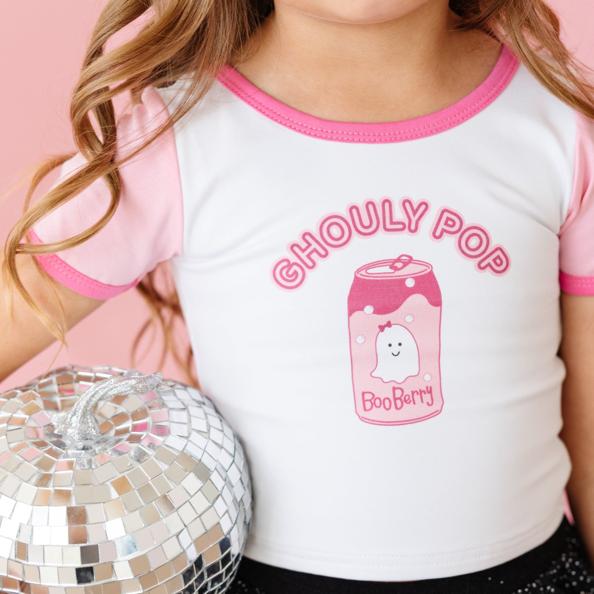 little girl holding mirrored pumpkin in white cotton blend tee with