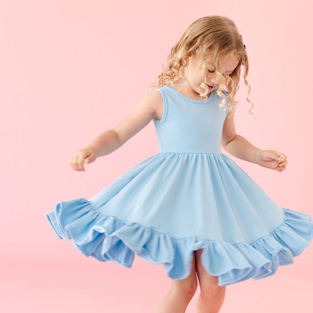 little girl twirling in light blue cotton summer dress