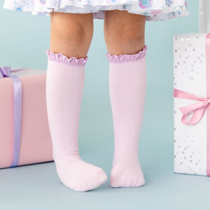 little girl in lilac knee high socks with lace trim and matching pastel holiday dress