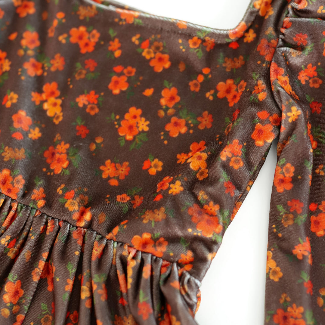 closeup of brown velvet dress bodice with orange flower print