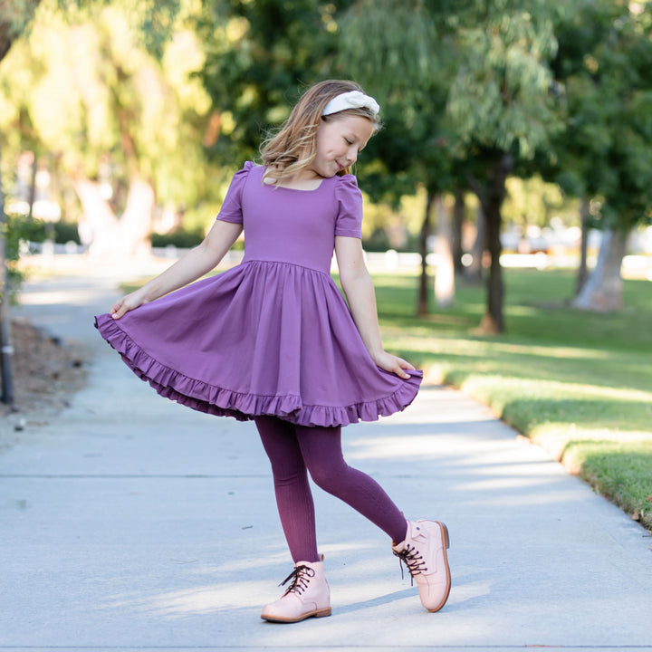 little girl in purple twirl dress and matching dark purple cable knit tights
