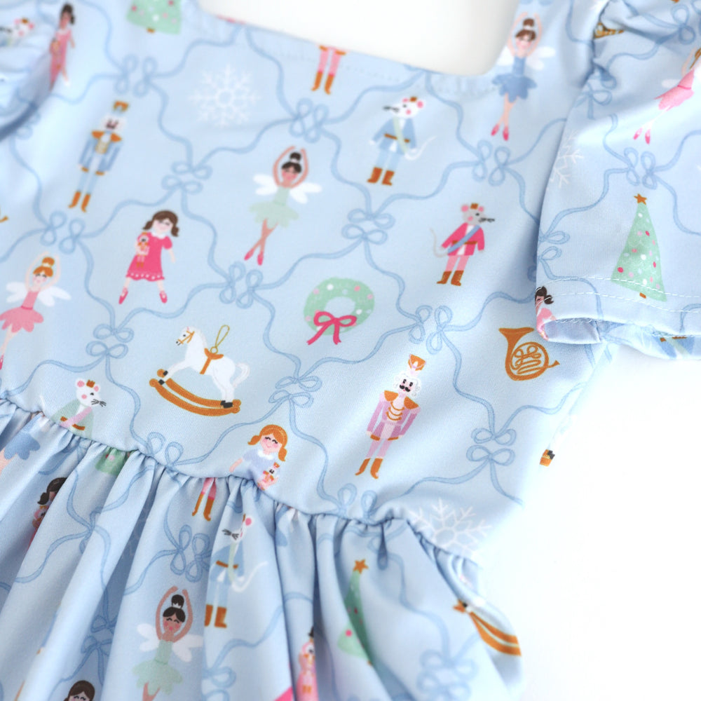 closeup of girls' blue square neck Christmas dress with nutcracker print