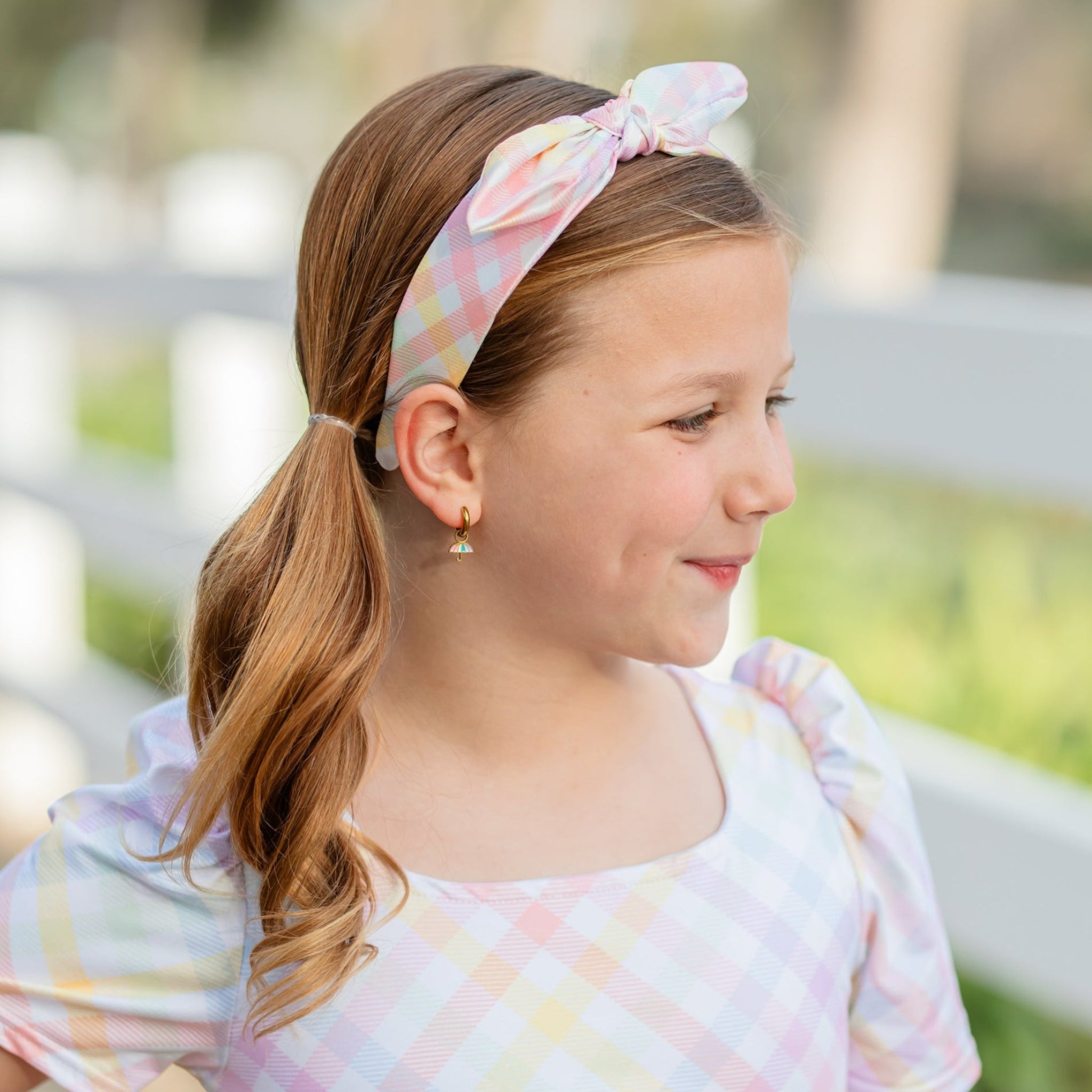 girl wearing satin headband with knotted bow detail and matching square neck dress in pastel gingham print for spring and easter