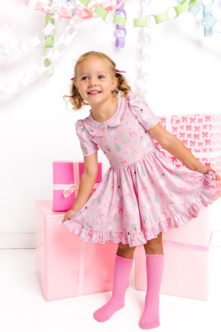little girl in pink winter wonderland short sleeve twirl dress with collar paired with matching pink knee high socks