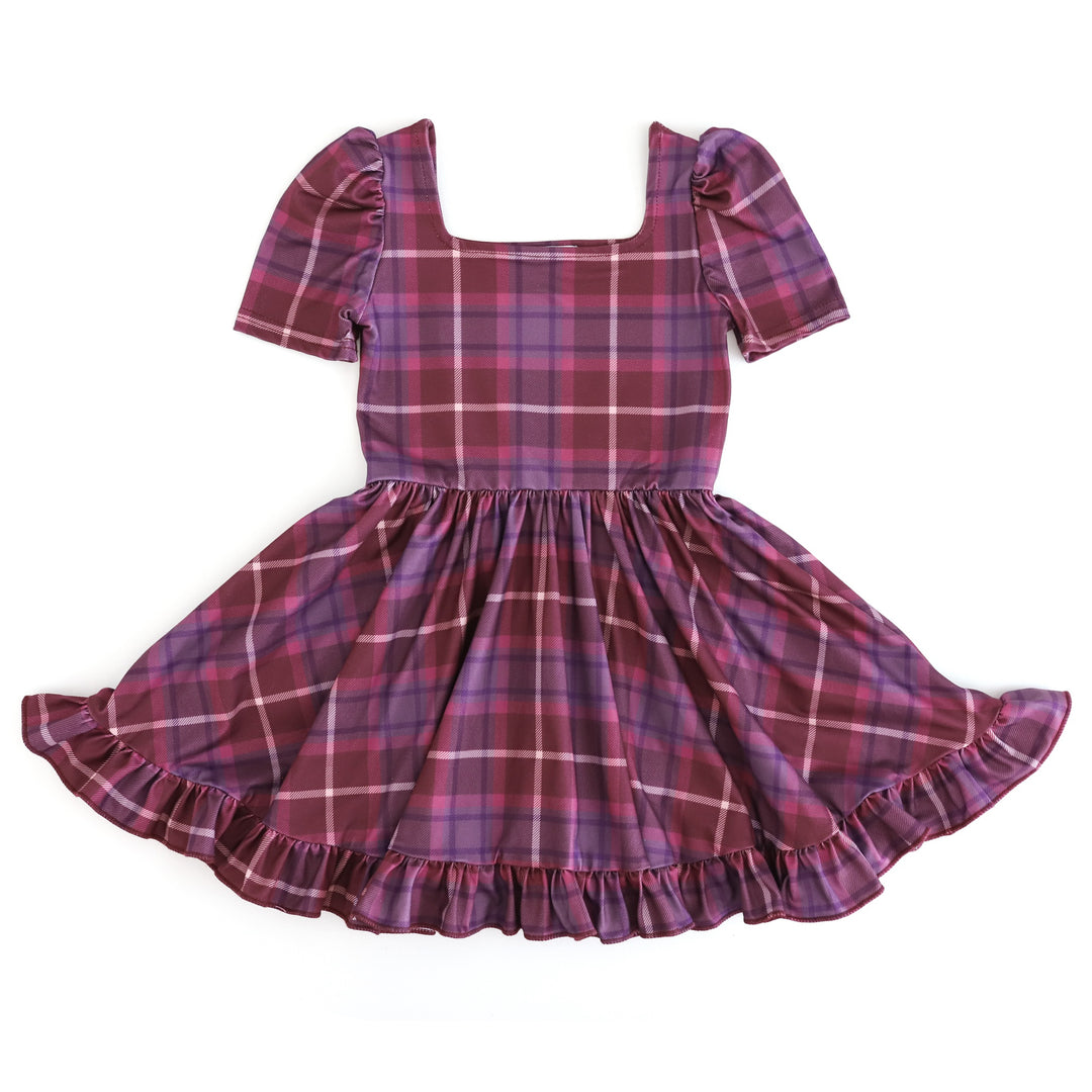 girl's purple and burgundy plaid twirl dress with square neckline, puffed sleeve and ruffle hemline for fall family photos
