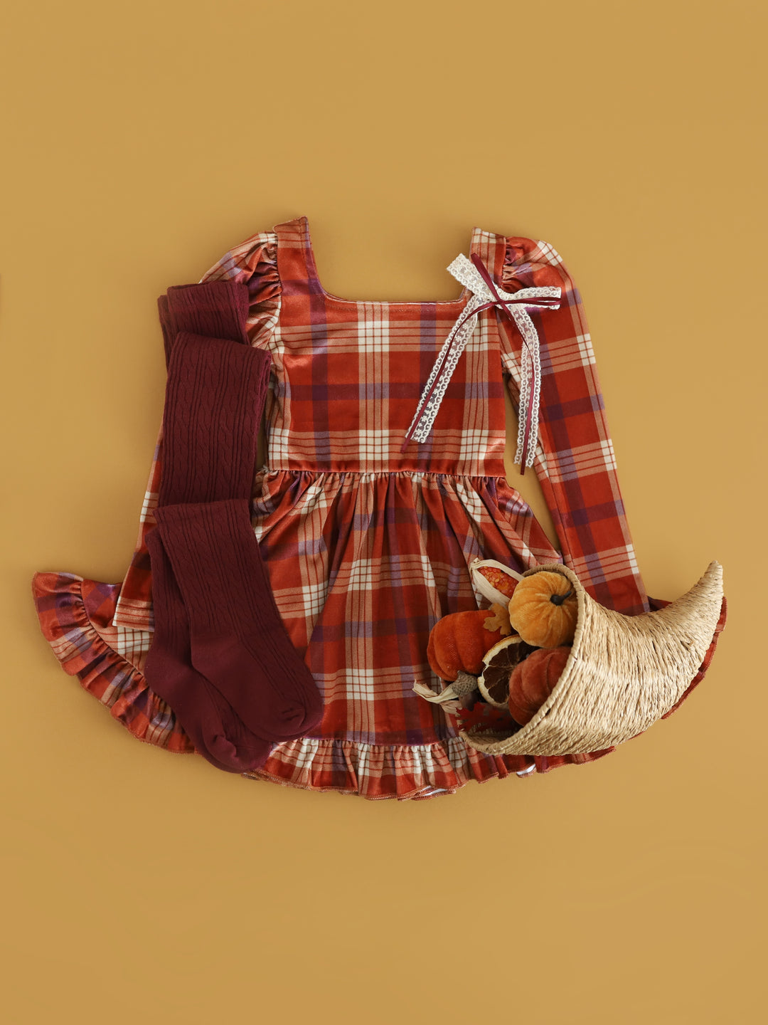 girls' pumpkin velvet plaid dress for Thanksgiving paired with burgundy cable knit tights and cream with burgundy lace bow