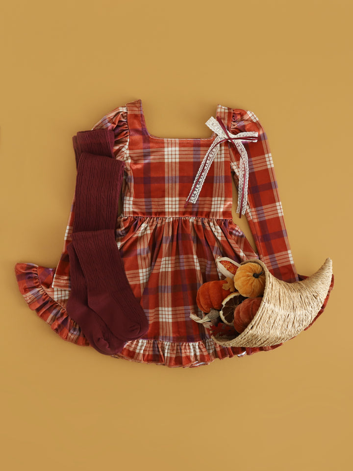 girls' pumpkin velvet plaid dress for Thanksgiving paired with burgundy cable knit tights and cream with burgundy lace bow