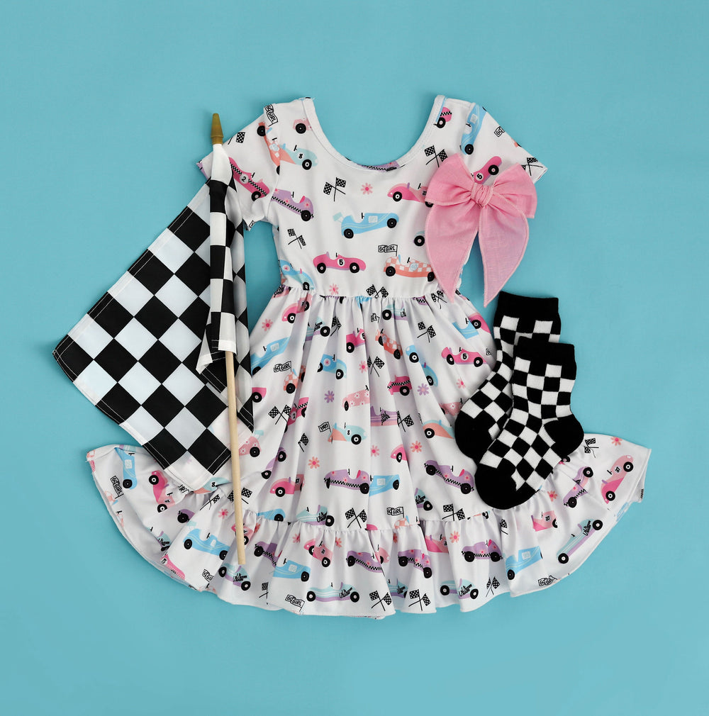 girls' race care print twirl dress styled with checkered socks and a pink hair bow