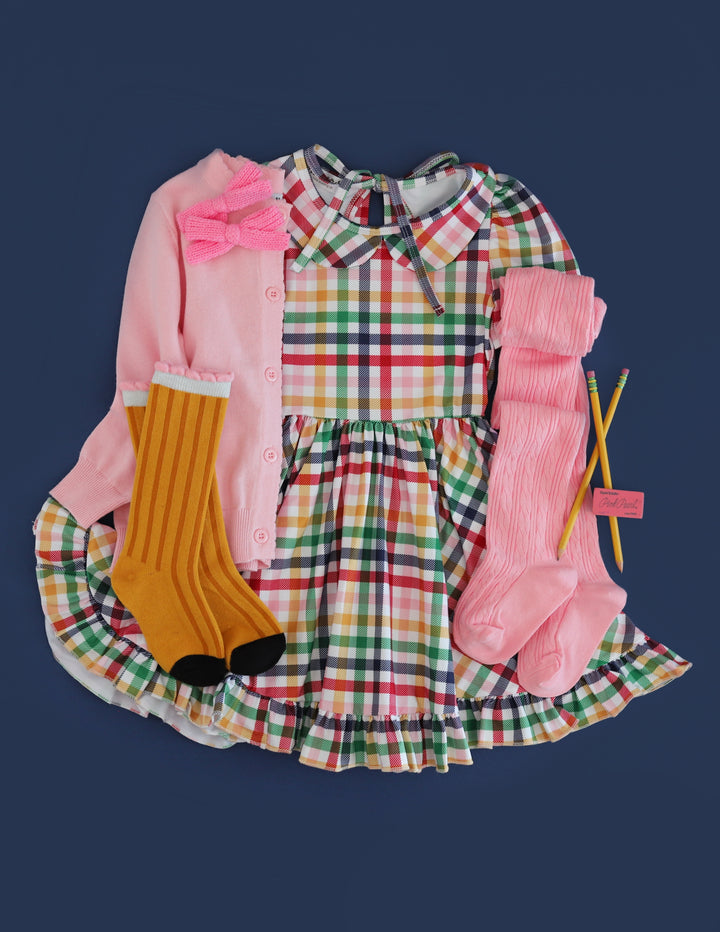 girl's back to school primary rainbow gingham twirl dress with collar, matching pink tights, cardigan and pigtail bows and knee highs with pencil design
