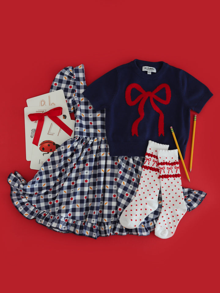 girl's back to school themed gingham twirl dress paired with navy short sleeve bow sweater and matching red bow knee highs