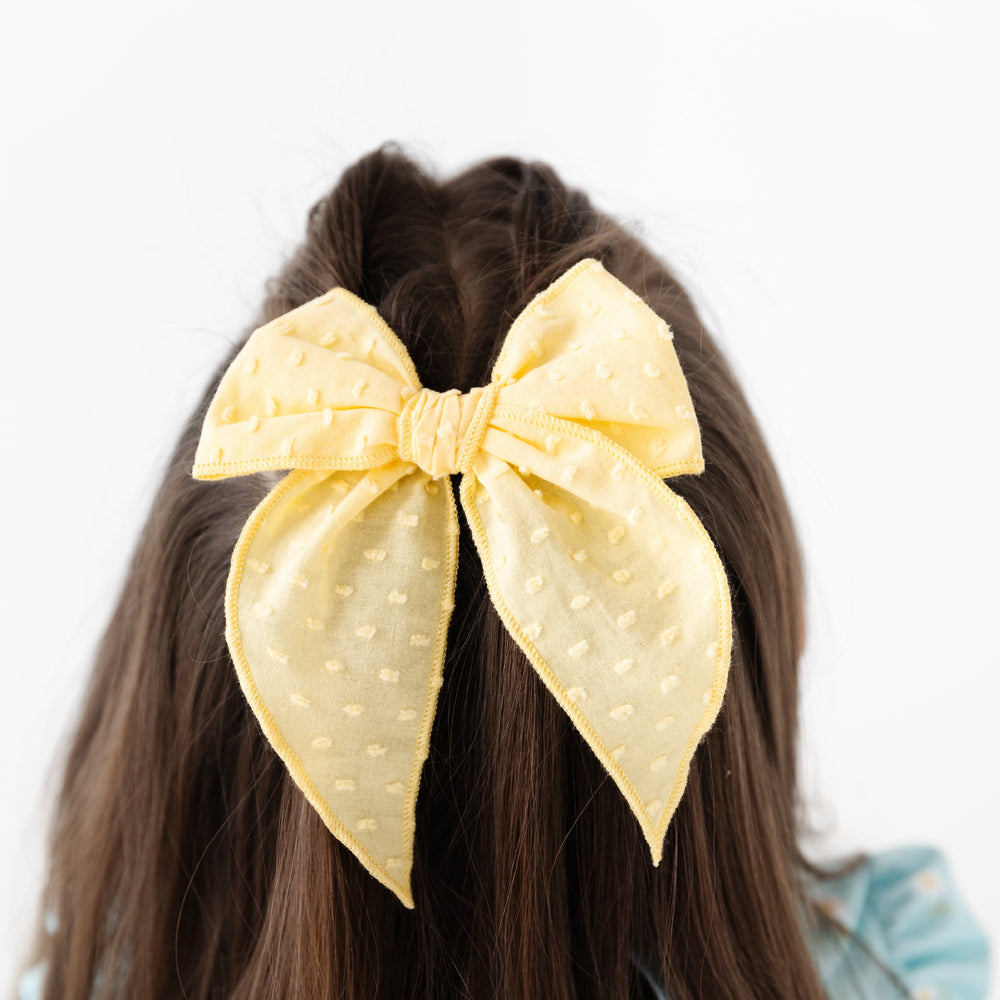 girl wearing sunshine yellow textured dot girls hair bow