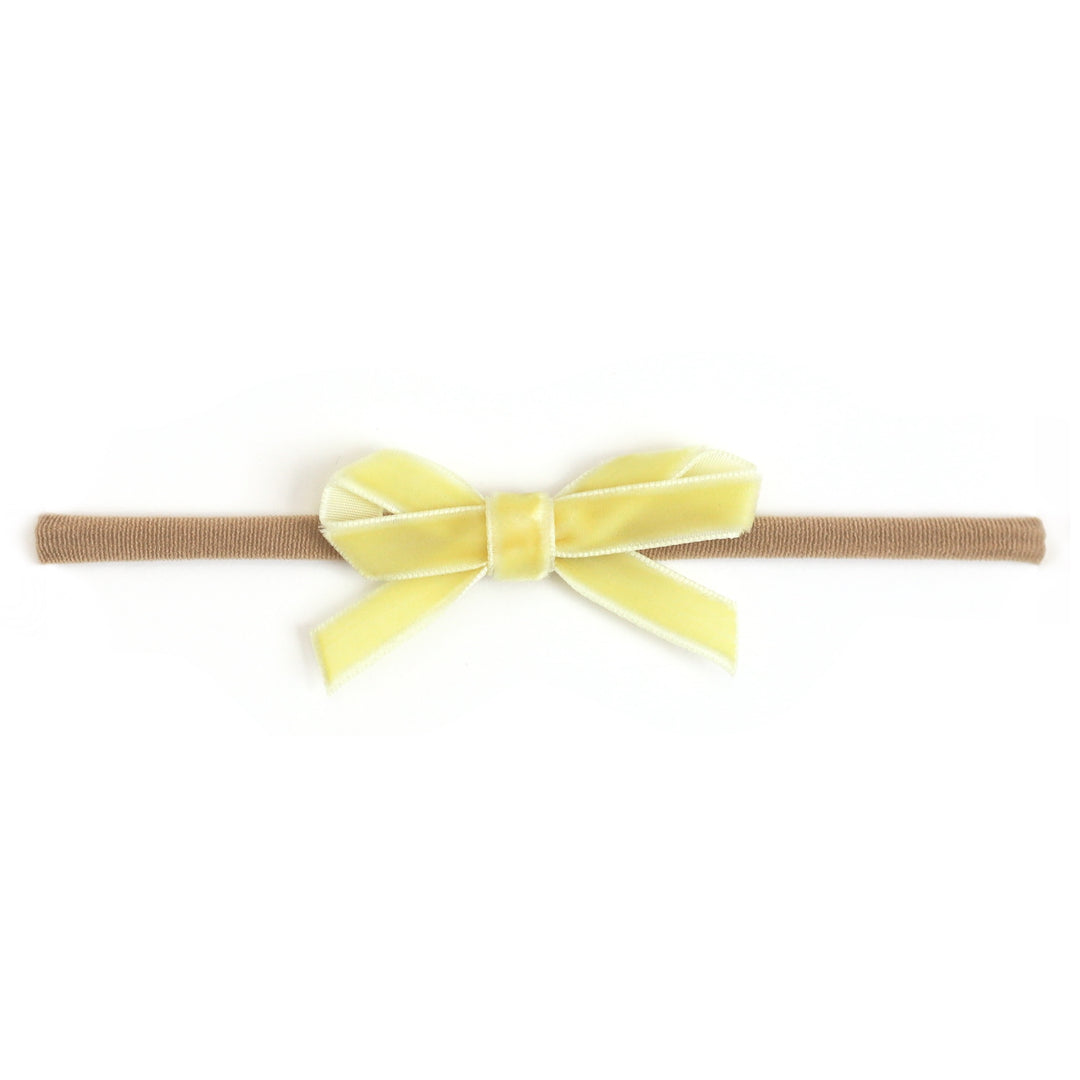 baby girl's pastel yellow velvet ribbon bow on stretchy nylon headband for spring and easter