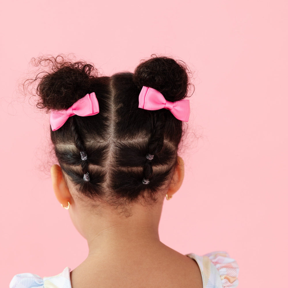 little girl in pink satin pigtail bows on clips for spring