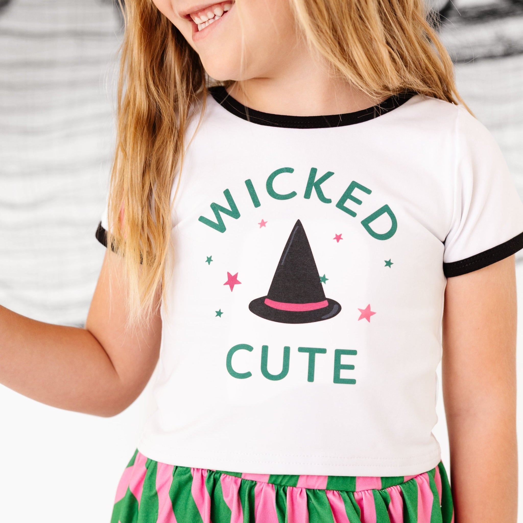 closeup of little girl in white with black binding short sleeve top with