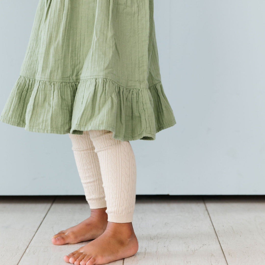 Little girl in vanilla cream cable knit leggings