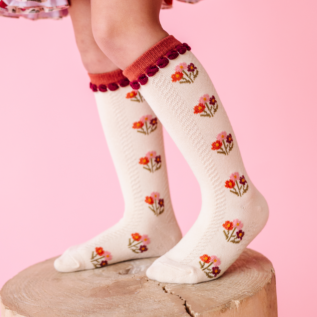 young girl in navy twirl dress paired with coordinating ivory and blue fall floral knee socks 