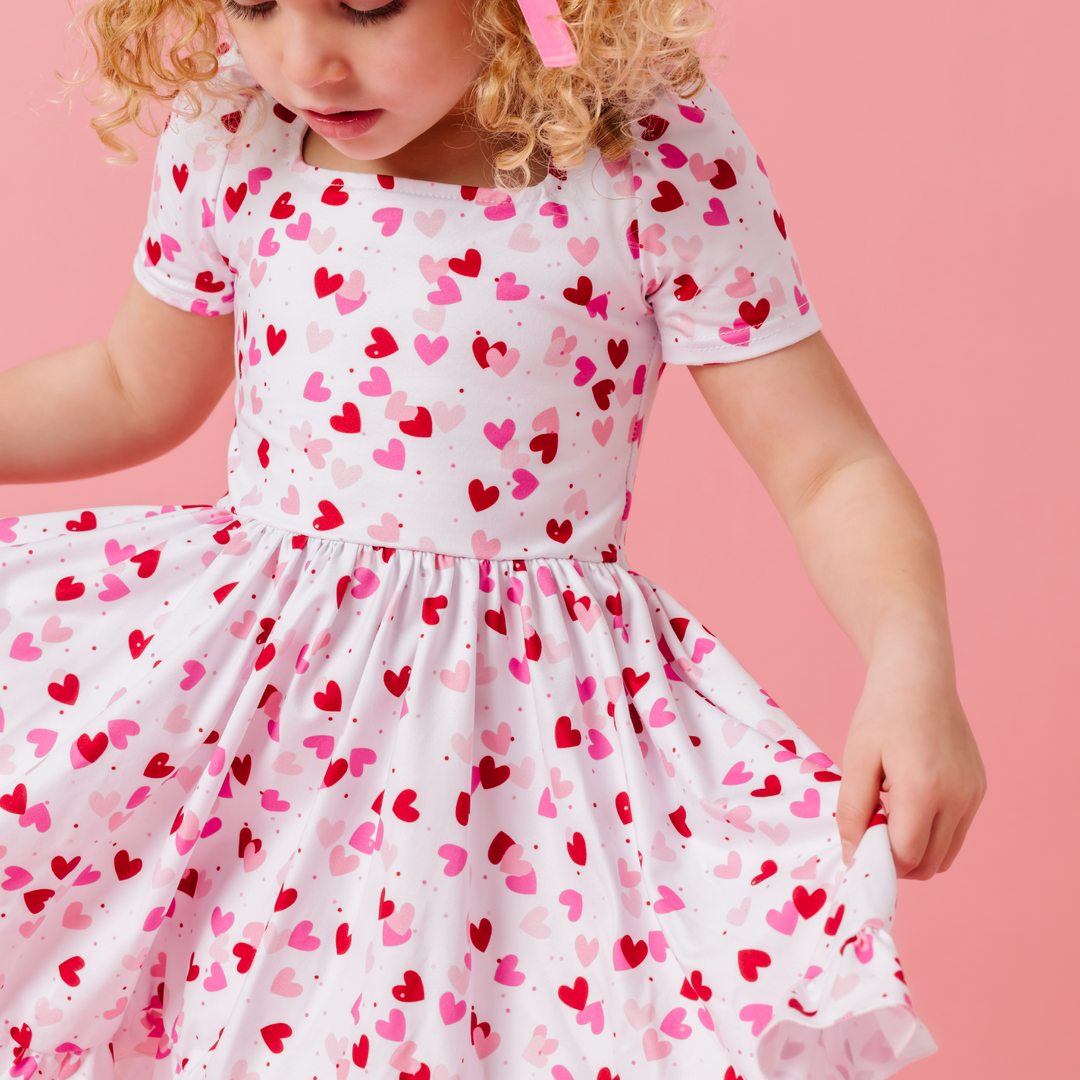 little girl twirling in rainbow heart dress