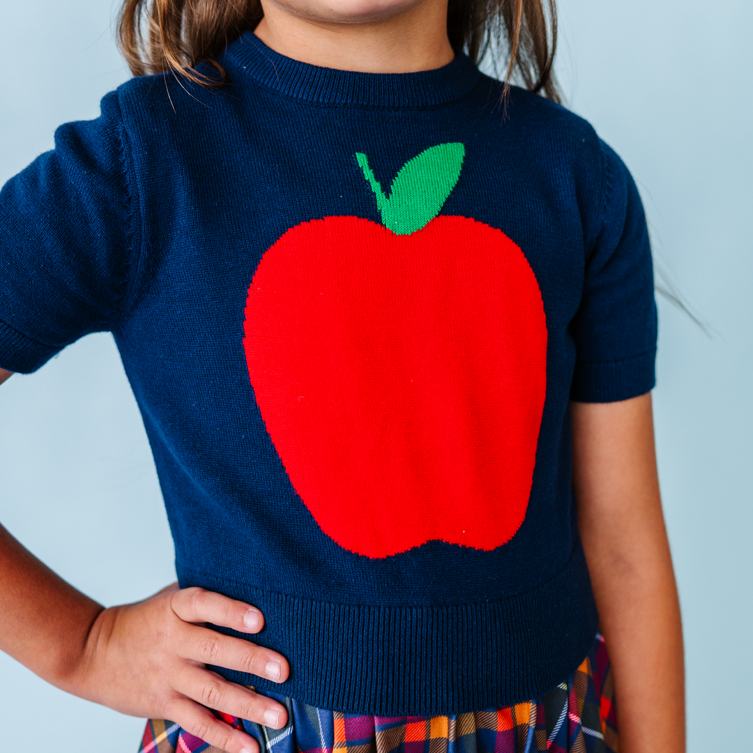 hand embroidered rainbow design knit sweater on little girl in rainbow stripe dress