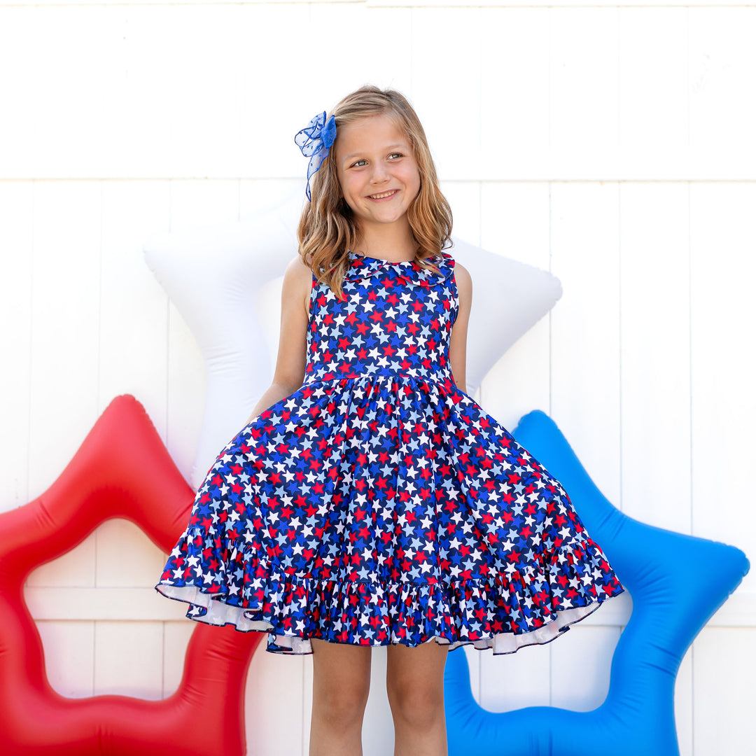 little girl wearing red, white and blue star print 4th of july dress