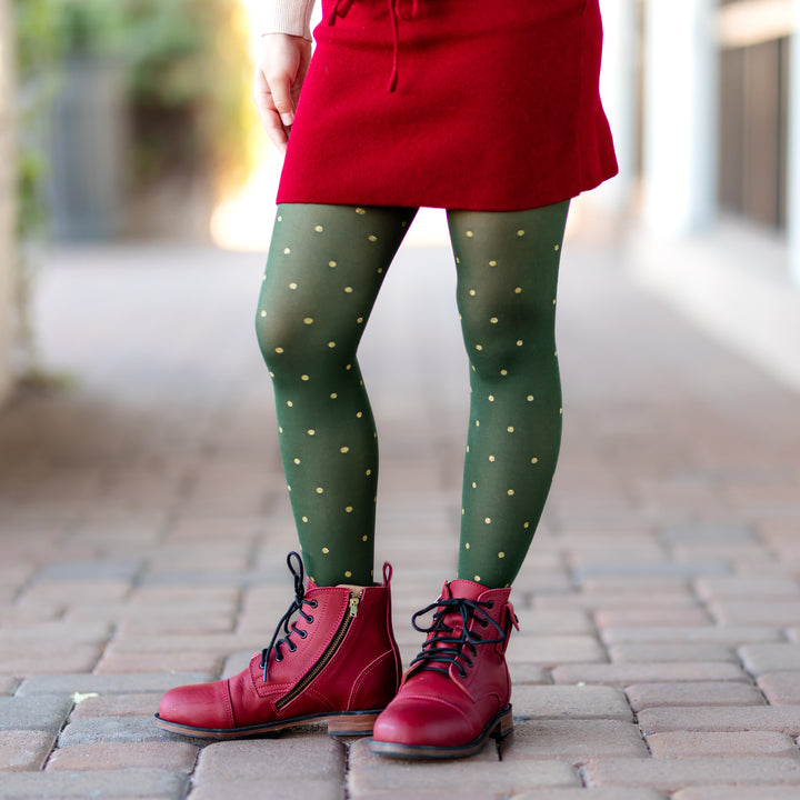 little girl in forest green nylon tights with gold glittery dots and crimson knit skirt