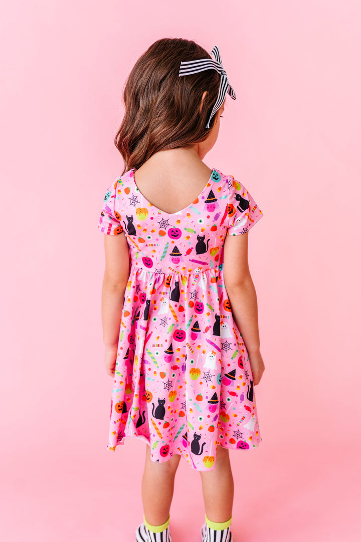 little girl facing away from camera to show V-neck on back of pink Halloween oprnt twirl dress