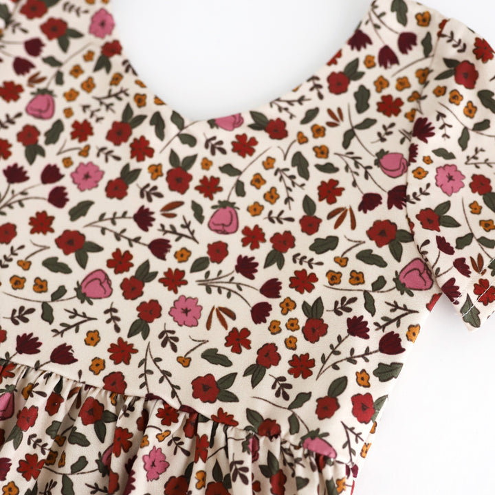 closeup of cream v-neck dress bodice with floral print in burgundy, mustard, rust and olive