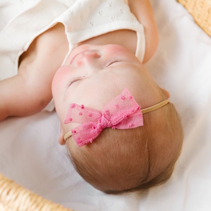 baby in sheer pink swiss dot bow with nylon headband