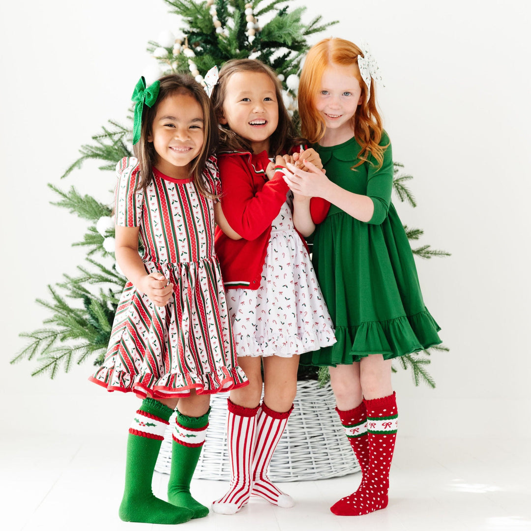 little girls wearing christmas dresses with matching knee high socks