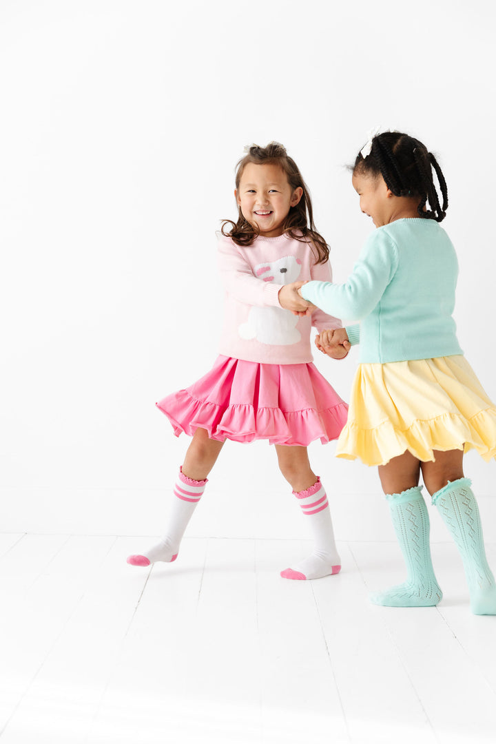 little girls holding hands wearing easter sweaters