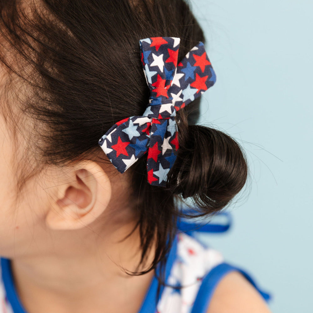 little girl in 4th of july print dress with cute star pattern hair bow 