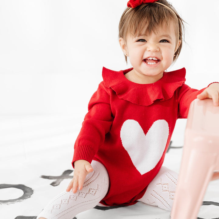 baby girl wearing valentines heart romper with white pointelle footless tights