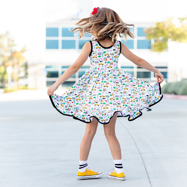 little girl twirling in nyc inspired print dress