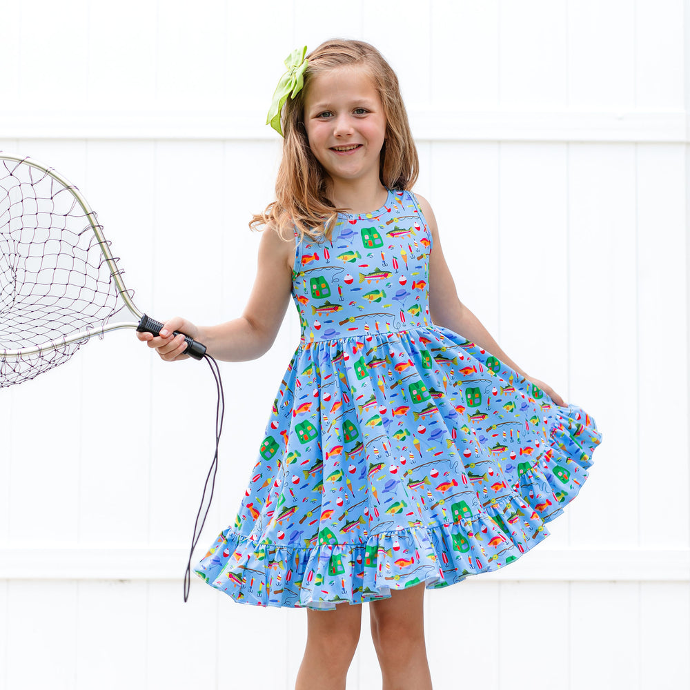 little girl holding net wearing fishing themed tank top style twirl dress