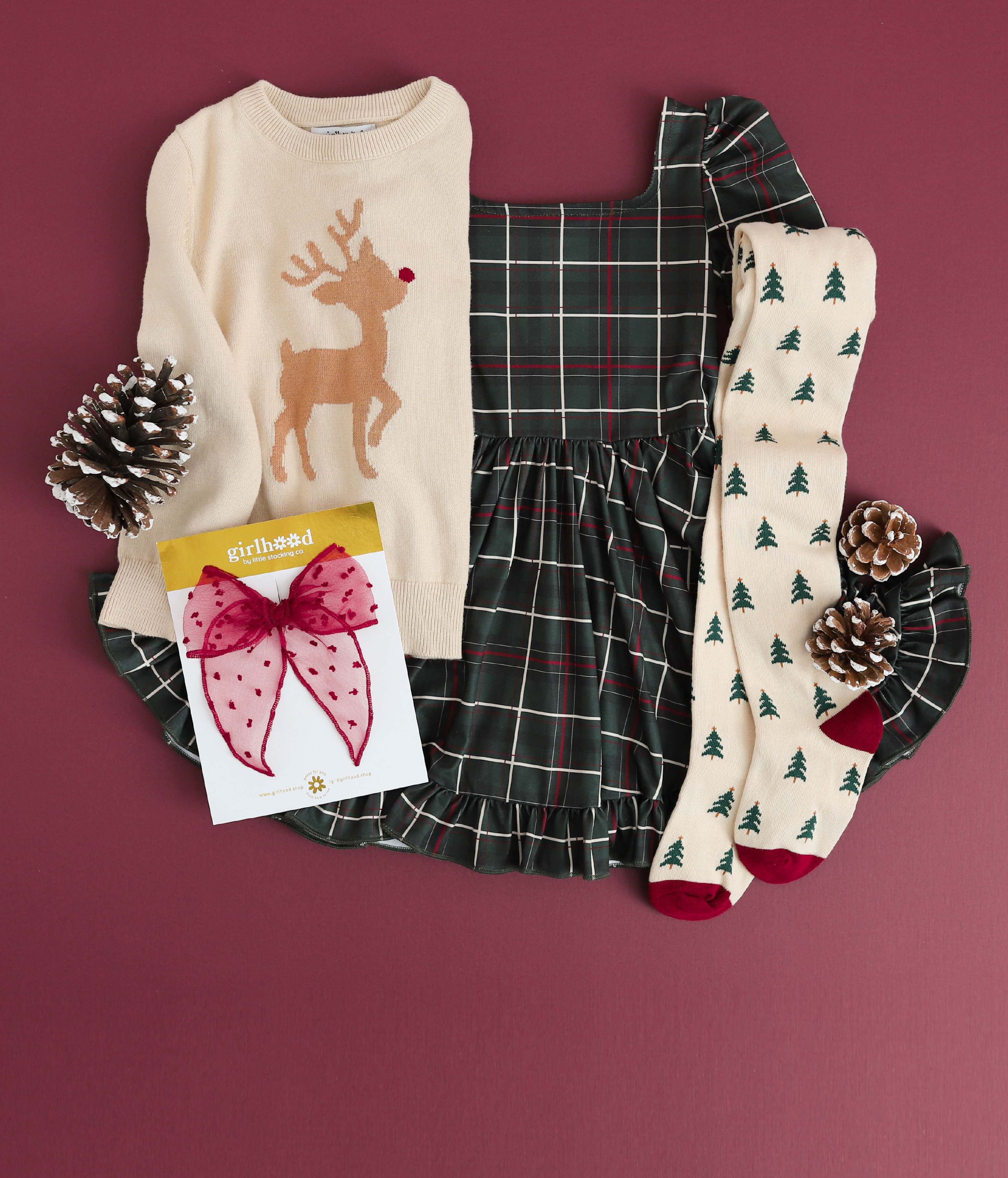 girls forest green plaid dress with reindeer sweater, matching knit tights with pine tree pattern and sheer crimson bow