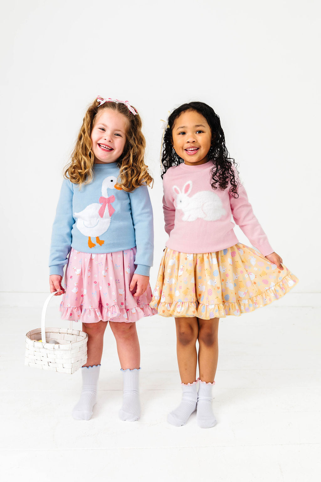 little girls wearing easter outfits with matching dresses, sweaters and socks