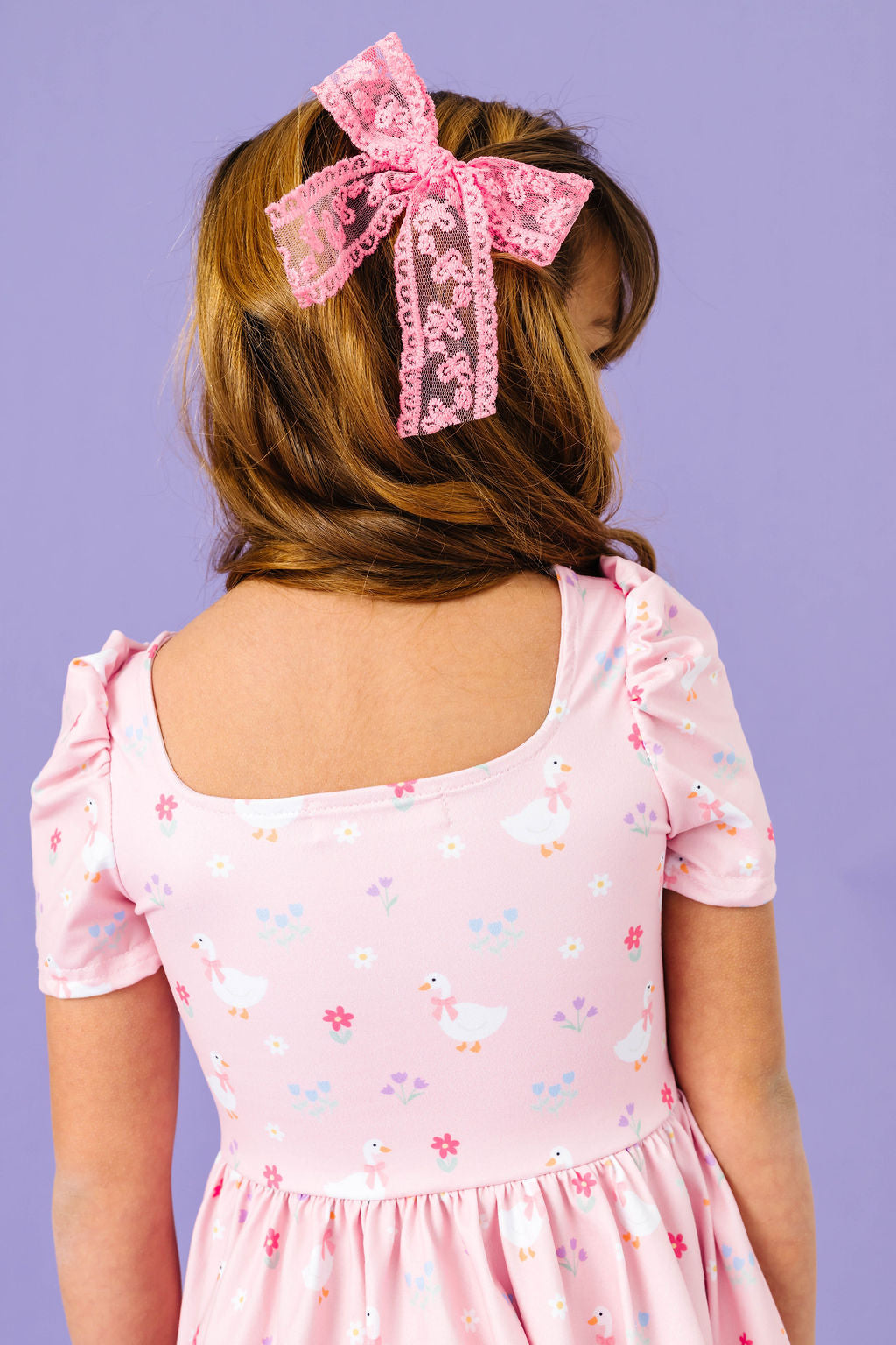 back detail of pink goose print girls dress and matching pink lace hair bow