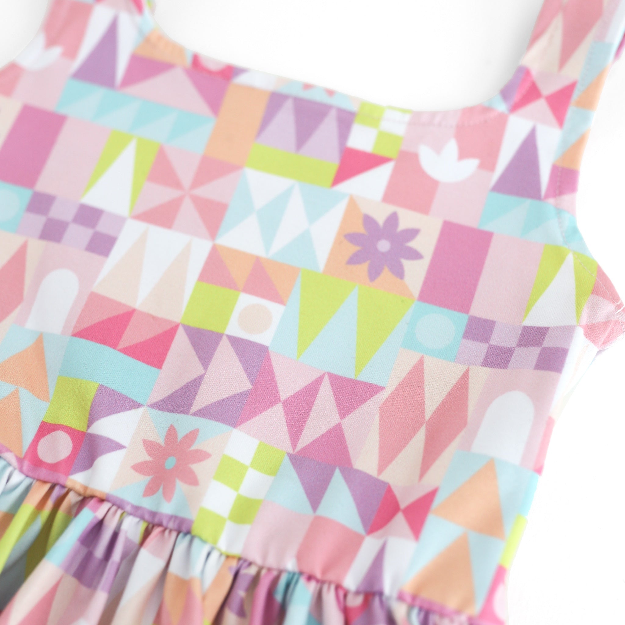 closeup of geometric twirl dress pattern in shades of pink, purple, sky blue and lime green