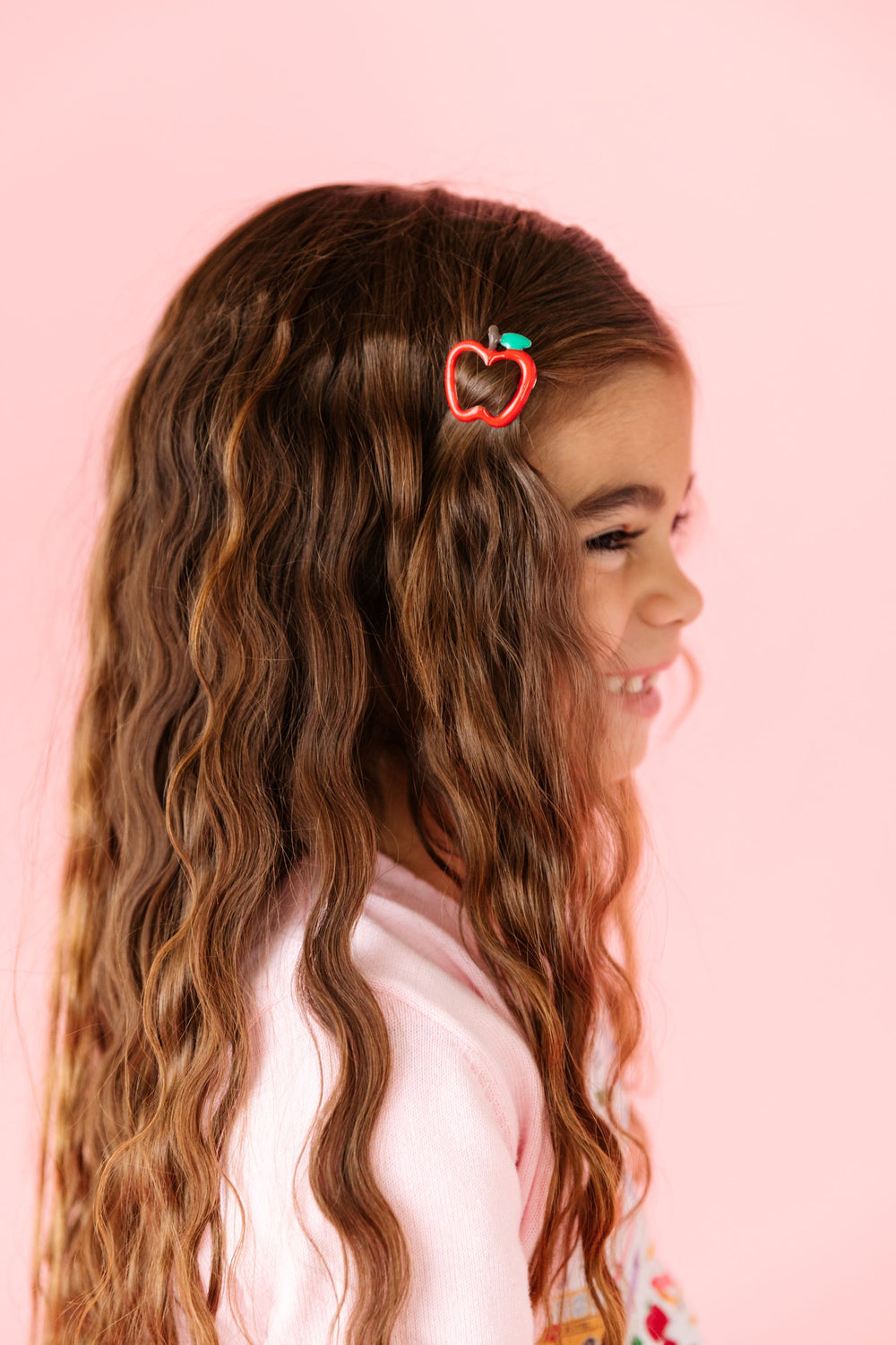 little girl in back to school themed outfit and matching red apple hair clip
