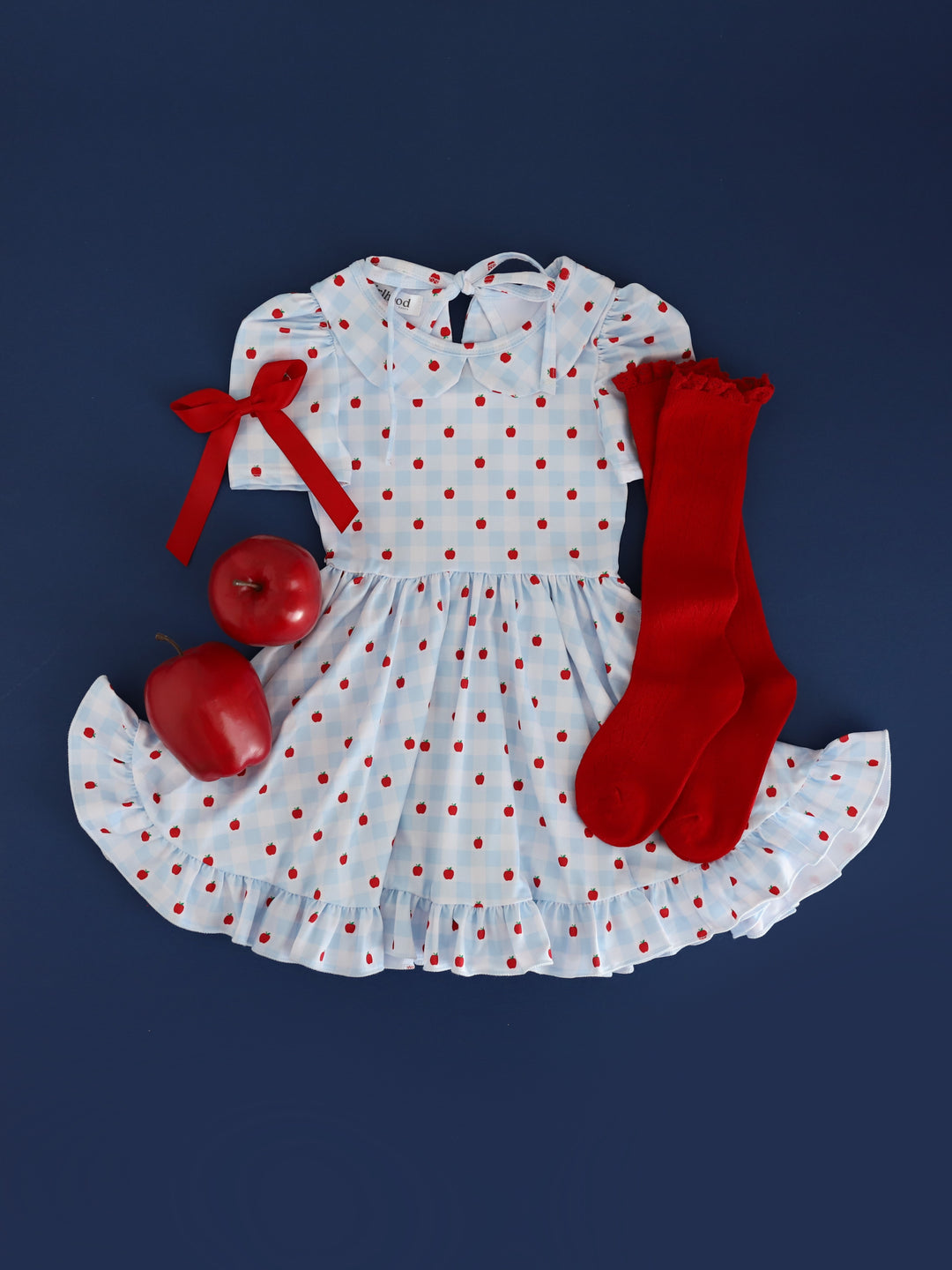 girls light blue and white gingham and apple print short sleeve twirl dress with collar paired with apples, bright red pointelle lace top knee socks and bright red satin hair bow