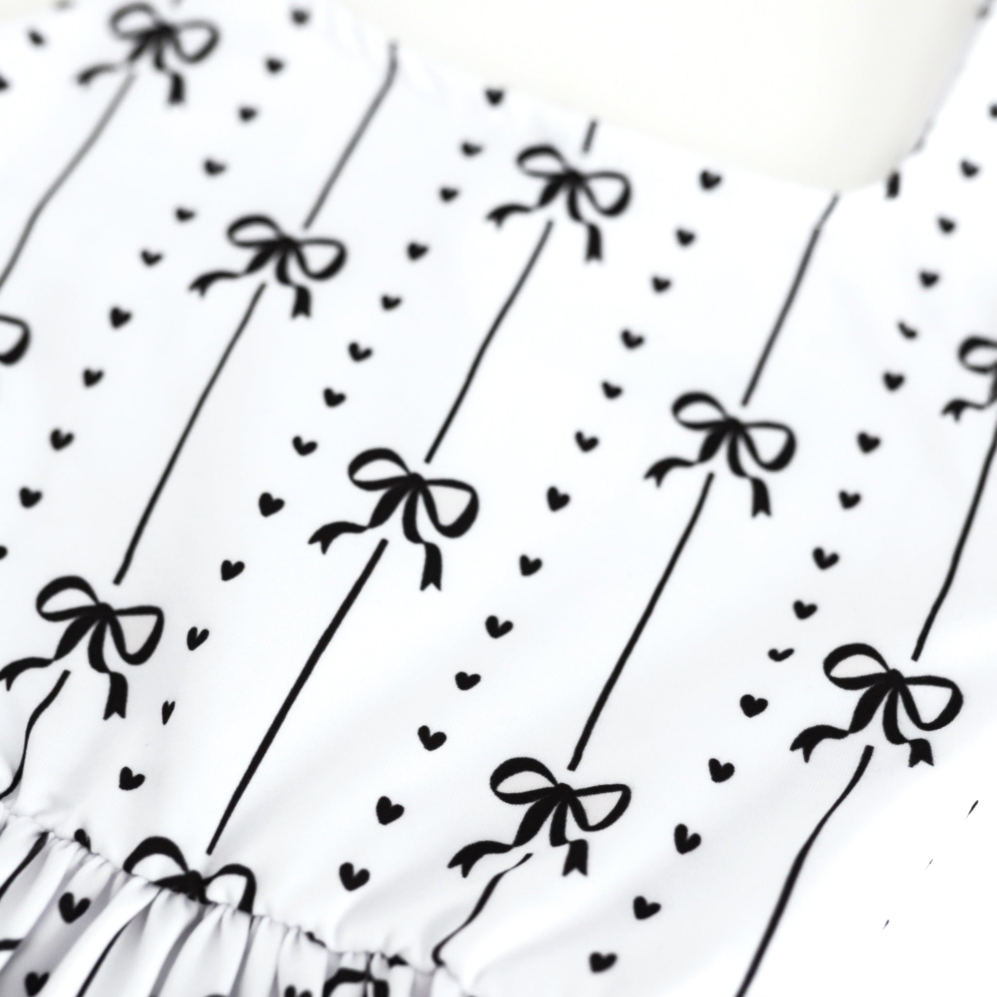 closeup of black ribbon and heart print on white base