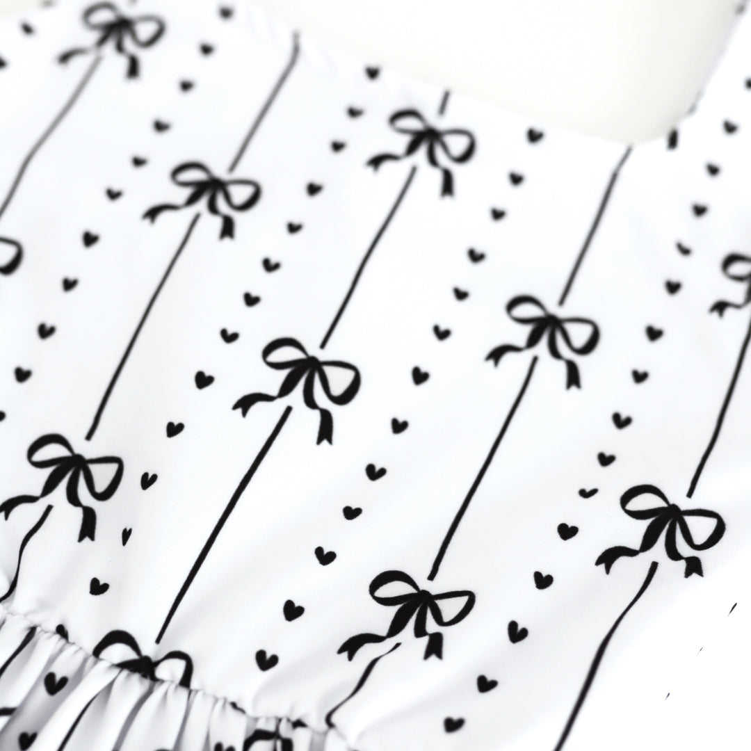 closeup of black ribbon and heart print on white base