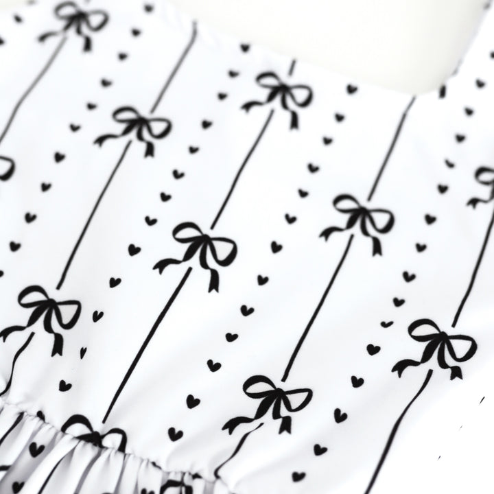 closeup of black ribbon and heart print on white base